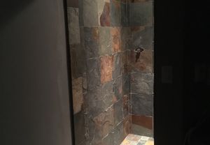 Rustic walk-in slate tile shower with multicolor stone pattern and recessed lighting in a Bozeman home