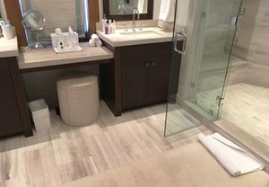 Modern Bozeman bathroom with porcelain tile flooring, floating vanities, and frameless glass shower surround